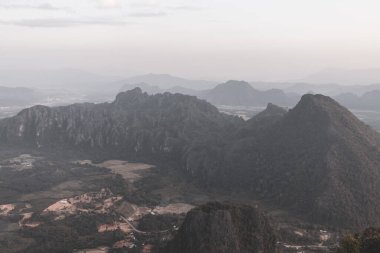Tropikal orman tepeleriyle dağ zirvesi kayaları ve Southeastasia Asia 'daki Vang Vieng Vientiane Vientiane Eyaleti Laos' ta inanılmaz renkli altın gün batımı..