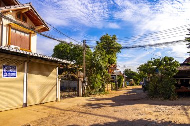 Güneydoğu Asya 'daki Vientiane Laos' ta binaları olan tipik renkli caddeler engebeli yollar..