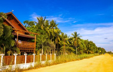 Güneydoğu Asya 'daki Vientiane Laos' ta binaları olan tipik renkli caddeler engebeli yollar..