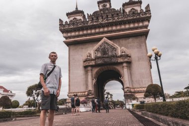 Patuxai Patuxay Zafer Kapısı ve Güneydoğu Asya 'daki Vientiane Laos kentindeki şehir parkında erkek turist gezgini..