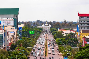 Restoranları olan sokak ve yol manzarası Güneydoğu Asya 'daki Vientiane Laos' ta insanların araba ve trafiğini gösteriyor..