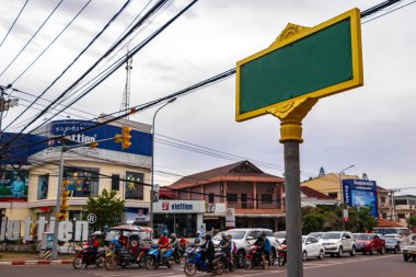 Güneydoğu Asya 'daki Vientiane Laos' ta sokak insanlarının arabaları ve trafiği ile tipik yeşil turkuaz yol işareti..
