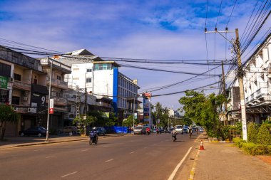 Mağazaları olan tipik renkli cadde ve yol Güneydoğu Asya 'daki Vientiane Laos' ta insan arabaları ve trafik mağazaları..