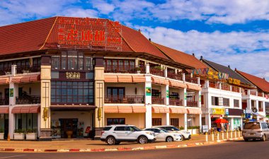 Mağazaları olan tipik renkli cadde ve yol Güneydoğu Asya 'daki Vientiane Laos' ta insan arabaları ve trafik mağazaları..
