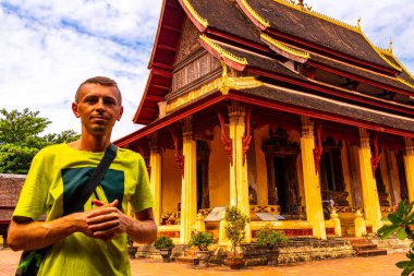 Male tourist man at Wat Si Saket buddhist buddha temple in Vientiane Laos in Southeastasia Asia. clipart