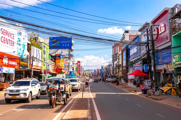 Mağazaları olan tipik renkli cadde ve yol Güneydoğu Asya 'daki Vientiane Laos' ta insan arabaları ve trafik mağazaları..