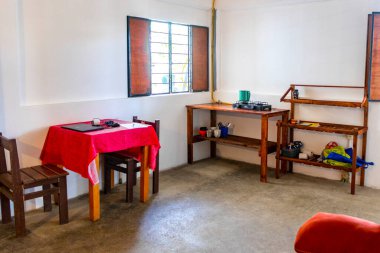 Simple small apartment hotel room with bed table TV kitchen and refrigerator in Zicatela Puerto Escondido Oaxaca Mexico. clipart