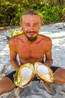 Adam Playa del Carmen Quintana Roo Meksika sahilinde hindistan cevizi açıyor..