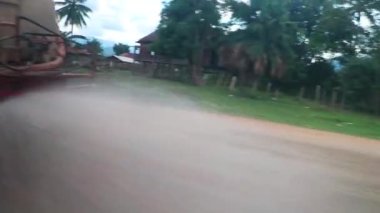 Güney Asya 'daki Vientiane Eyaleti Laos' taki tozlu yola su püskürten kamyon,.