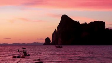 Amphoe Mueang Krabi Tayland ve Güneydoğu Asya 'daki Koh Phi Phi Don Adası' ndaki muhteşem kireçtaşı kayaları arasındaki plajda nefis ve göz kamaştırıcı bir altın gün batımı ve tropikal cennet manzarası..