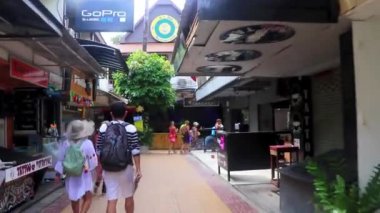 Güneydoğu Asya 'da Ao Nang Amphoe Mueang Krabi Tayland' daki Koh Phi Phi Don adasında elinde Chang 'in su şişesiyle turist caddesinde yürümek..