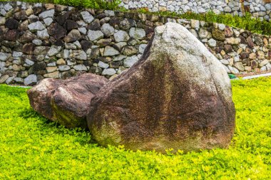 Decorative rocks on manicured tropical lawns in Naithon Beach Sakhu Thalang on Phuket island Thailand in Southeastasia Asia. clipart