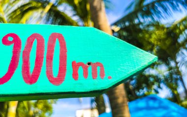 Renkli yön işaretleri Zicatela Puerto Escondido Oaxaca Meksika 'da kilometrelerce ve uzaklıktaki yerlere ok işareti veriyor..