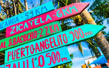 Colorful direction signs arrows to beaches and places in Zicatela Puerto Escondido Oaxaca Mexico. clipart