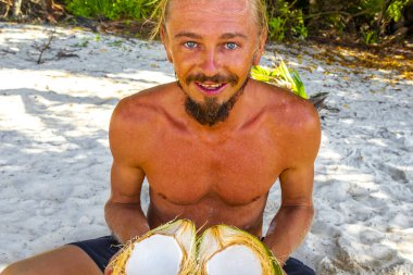 Adam Playa del Carmen Quintana Roo Meksika sahilinde hindistan cevizi açıyor..