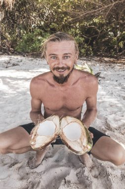 Adam Playa del Carmen Quintana Roo Meksika sahilinde hindistan cevizi açıyor..