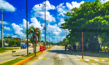 Driving through the small village with streets houses and public places in Kantunilkin Lazaro Cardenas in Quintana Roo Mexico. clipart