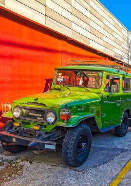 Green off road vehicle on the side of the road in the city in Alajuela Costa Rica in Central America. clipart