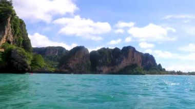 Uzun kuyruklu tekneler, Ao Nang Krabi Tayland 'daki Ailay Batı Sahili' ndeki kireçtaşı kayaları ve turkuaz su arasındaki ünlü sahil gölünde gezinti yapıyor..
