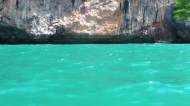 Uzun kuyruklu tekneler, Ao Nang Krabi Tayland 'daki Ailay Batı Sahili' ndeki kireçtaşı kayaları ve turkuaz su arasındaki ünlü sahil gölünde gezinti yapıyor..