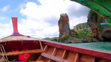 Güneydoğu Asya 'daki Ao Nang Amphoe Mueang Krabi Tayland' daki tropikal kireçtaşı kayaları ve turkuaz su içinde Ao Nang Sahili 'nden Railay Batı Sahili' ne uzun kuyruk teknesiyle gitmek..