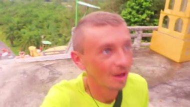 Yakışıklı erkek turist Wat Phu Khao Phra Maha Phothisat Çin tapınağında yürüyor Ao Nang Amphoe Mueang Krabi Tayland tepesinde.