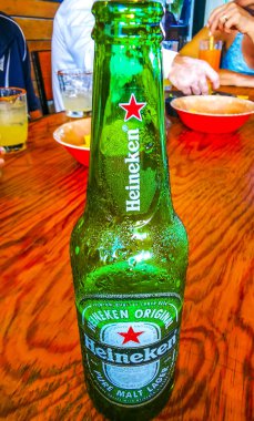 Puerto Morelos Quintana Roo Mexico 'daki restoranda ahşap masada Heineken bira şişesi..