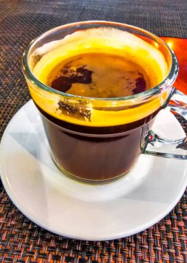 Playa del Carmen Quintana Roo Meksika 'daki restoran kafeteryasında bir tabak kaşık ve tabakla bir bardak koyu americano kahvesi..