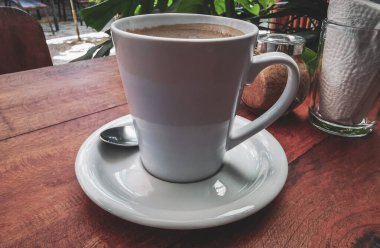 Playa del Carmen Quintana Roo Meksika 'daki restoran kafeteryasında bir tabak kaşık ve tabakla bir bardak koyu americano kahvesi..