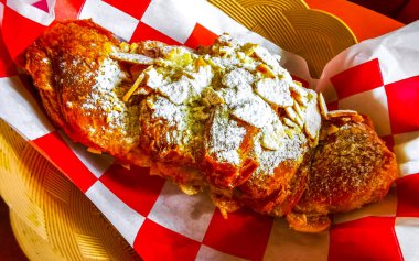 Croissant with powdered sugar and almonds in a vintage basket in Playa del Carmen Quintana Roo Mexico. clipart