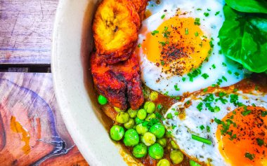 Playa del Carmen Quintana Roo Mexico 'da kızarmış yumurta, ıspanak, patates ve bezelye tabağı..