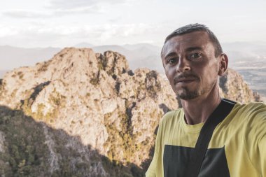 Tropik orman tepeleri, kayalıkları ve Vang Vieng Vientiane Vientiane Eyaleti Laos 'unda altın renkli günbatımı ile dağ manzarası olan erkek turist..