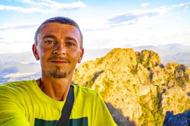 Tropik orman tepeleri, kayalıkları ve Vang Vieng Vientiane Vientiane Eyaleti Laos 'unda altın renkli günbatımı ile dağ manzarası olan erkek turist..