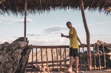 Tropik orman tepeleri, kayalıkları ve Vang Vieng Vientiane Vientiane Eyaleti Laos 'unda altın renkli günbatımı ile dağ manzarası olan erkek turist..
