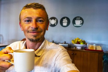 Güneydoğu Asya 'daki Khao Lak Amphoe Takua Pa Phang Nga Tayland' daki otel kantininde kahve içen mutlu adam..