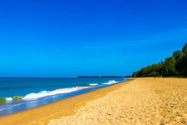 Turkuaz mavi su dalgalarıyla tropik doğal cennet Khuk Khak Sahili Güneydoğu Asya 'da Khao Lak Amphoe Takua Pa Phang Nga Tayland' da mavi gökyüzü ve palmiye ağaçları.
