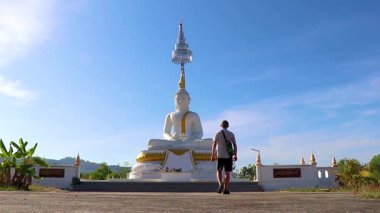 Genç ve yakışıklı turist Wat Phadung Tham Phothi tapınağındaki dev büyük Buda heykeli Khao Lak Phang nga Tayland.