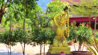 Altın sarısı Budist Buda ve Thokkathan anne figürü heykel heykeli Khao Lak Tayland 'daki Phanat Nikhom Tayland tapınaklarında.