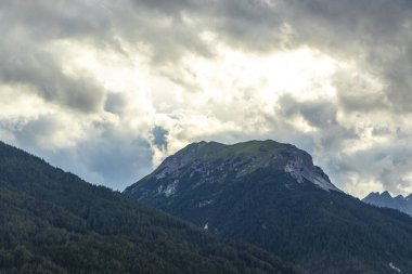 Dağ manzarası dağları yeşil tarlalar orman bulutları ve Alpler 'deki mavi gökyüzü Tyrol Avusturya.
