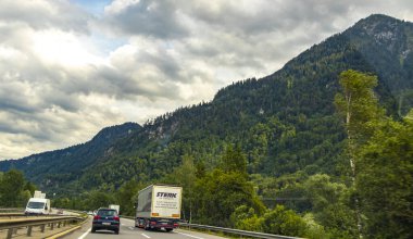 Alps Vorarlberg Avusturya 12. Temmuz 2019 Dağlık arazide otoyol yeşil tarlalar orman bulutları ve Alpler Vorarlberg Avusturya 'da mavi gökyüzü.
