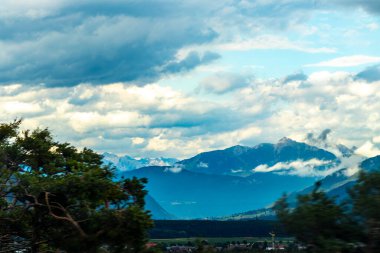 Dağ manzarası dağları yeşil tarlalar orman bulutları ve mavi gökyüzü Alpler Vorarlberg Avusturya.