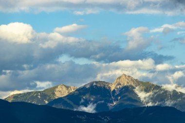 Dağ manzarası dağları yeşil tarlalar orman bulutları ve mavi gökyüzü Alpler Vorarlberg Avusturya.
