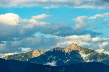 Dağ manzarası dağları yeşil tarlalar orman bulutları ve mavi gökyüzü Alpler Vorarlberg Avusturya.