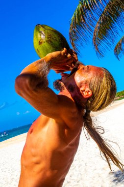 Playa del Carmen Quintana Roo Meksika sahilinde hindistan cevizi içen bir adam..