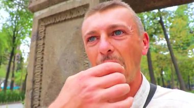 Adam Centro Historico City Mexico 'daki parkta beyaz bir çörek yiyor..