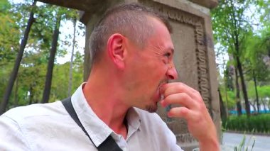 Adam Centro Historico City Mexico 'daki parkta beyaz bir çörek yiyor..