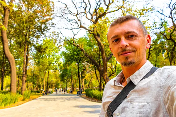 Alameda Central Park 'ta yakışıklı bir turist. Centro Historico City Mexico' daki patikalarında mermer zemin geçitleri var..