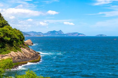 Rio de Janeiro Eyaleti Rio de Janeiro Brezilya 'da, Urca Red Beach Tropikal Cenneti Mavi Turkuaz Su Dalgaları Palmiye Ağaçları Kayalık Tepeler Kayalık Tepeler Sahil Kumu ve Beyaz Sahil Kumu.