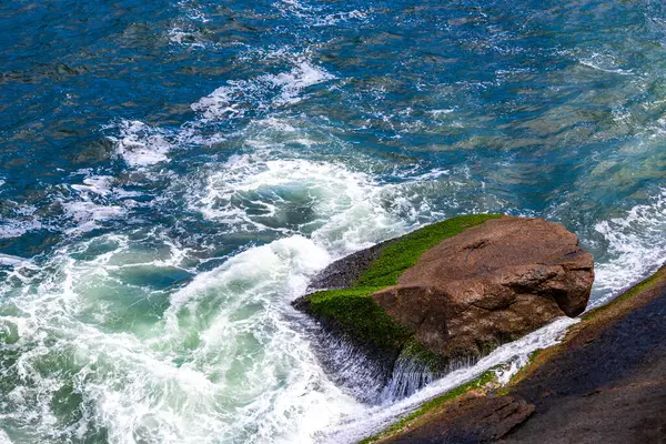 Rio de Janeiro Eyaleti Rio de Janeiro Brezilya 'da, Urca Red Beach Tropikal Cenneti Mavi Turkuaz Su Dalgaları Palmiye Ağaçları Kayalık Tepeler Kayalık Tepeler Sahil Kumu ve Beyaz Sahil Kumu.