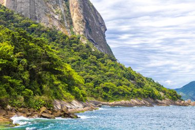 Rio de Janeiro Eyaleti Rio de Janeiro Brezilya 'da, Urca Red Beach Tropikal Cenneti Mavi Turkuaz Su Dalgaları Palmiye Ağaçları Kayalık Tepeler Kayalık Tepeler Sahil Kumu ve Beyaz Sahil Kumu.